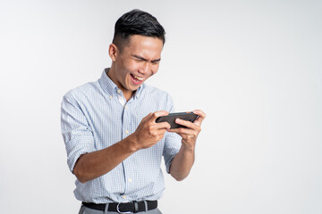 excited young asian man playing video game on his smartphone