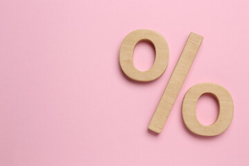 Wooden percent sign on pink background, flat lay. Space for text