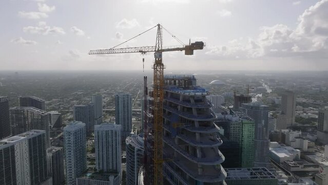 flying counter clockwise around construction crane atop skyscraper in Miami