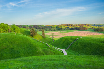 Obraz premium Kernave at spring, green mounds at historic capital in Lithuania