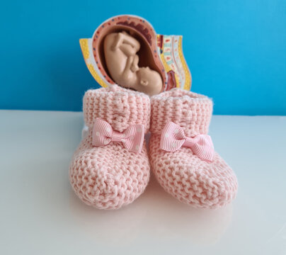 Baby fetus and pink slippers for newborns