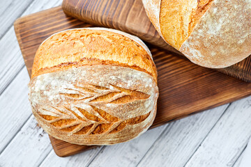 Freshly baked homemade wheat bread on a wooden background. Close-up, selective focus