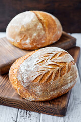 Freshly baked homemade wheat bread on a wooden background. Close-up, selective focus