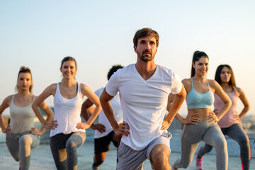 Group of fit people exercising together to stay healthy. Sport people workout city concept
