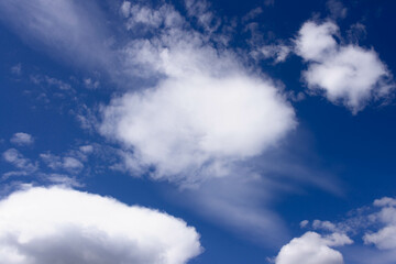 Fototapeta na wymiar Słoneczny, wiosenny dzień. Błękitne niebo pokryte kłębiastymi, biało szarymi chmurami.