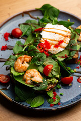 Buckwheat bread toasts with a poached egg, a sliced avocado, a shrimps, tomatoes and lettuce. Dietary menu. Flat lay.