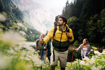 Group of fit healthy friends trekking in the mountains - obrazy, fototapety, plakaty