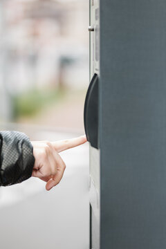 Unrecognizable Woman Getting A Ticket At The Parking Meter