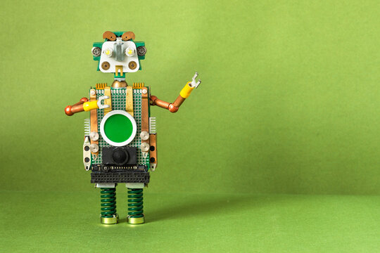 Steam punk robot toy. The mechanical character is robotic with copper arms, metal springs and a computer screen interface on his stomach. green background for text.
