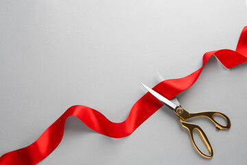 Red ribbon and scissors on light grey background, top view. Space for text - obrazy, fototapety, plakaty