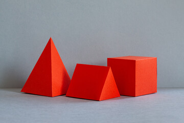 Red abstract geometrical figures on gray background. bright three-dimensional pyramid rectangular...