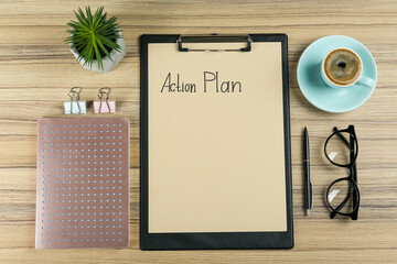 Fototapeta na wymiar Flat lay composition of clipboard with action plan on wooden table