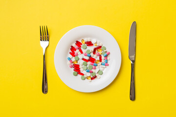 Many different weight loss pills and supplements as food on round plate. Pills served as a healthy meal. Drugs, pharmacy, medicine or medical healthycare concept