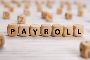 Word Payroll made of cubes on white wooden table