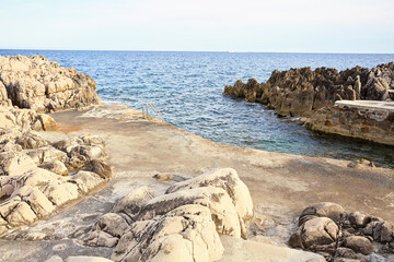 Fototapeta na wymiar light stones in coastal path and sea view