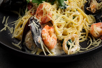 Bowl of gourmet seafood pasta on grey background