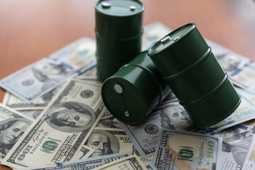 three barrels of oil standing on the dollar bills of money. the oil business, purchase sale, production, exchange, trading income.