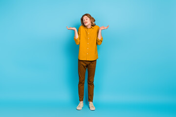 Full size photo of serious indifferent male shrugging shoulders feel sorry guilty isolated on blue color background
