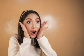 Wow and shocked face of Young Asian woman with open hand gesture. Advertising model concept.