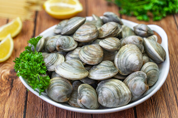 Fresh Littleneck Clams on a white plate with parsley.