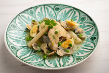 Basque hake with green sauce, asparagus, eggs and peas. Traditional Basque country tapas in the north of Spain.