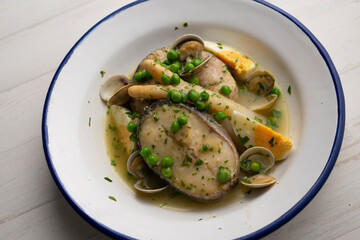 Basque hake with green sauce, asparagus, eggs and peas. Traditional Basque country tapas in the north of Spain.