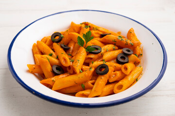 Macaroni with pepper sauce and black olives.
