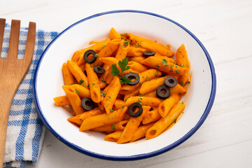 Macaroni with pepper sauce and black olives.