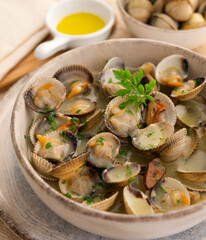 Cockles cooked in green sauce. Traditional Basque country recipe. Spanish cover.