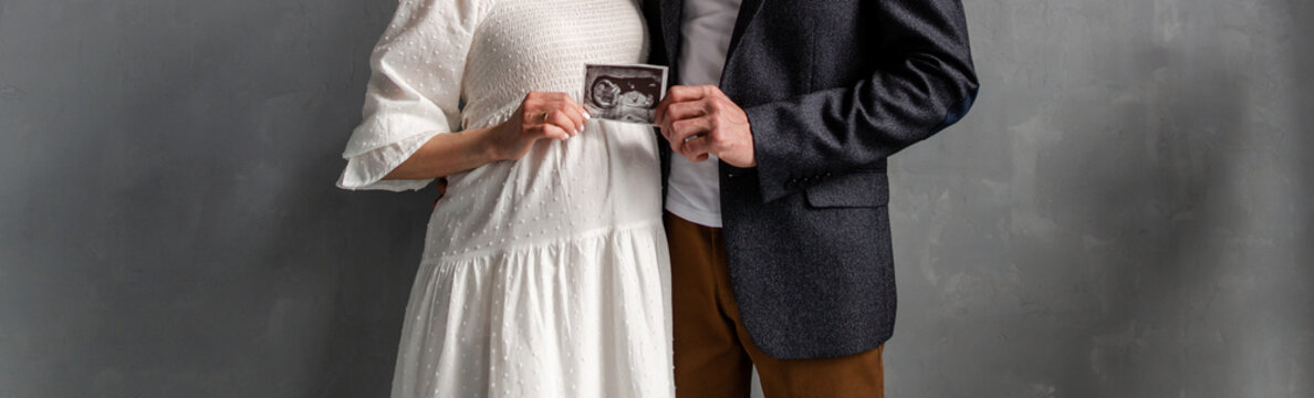 Married couple holding a picture of a baby in the womb