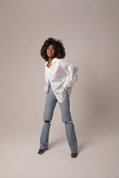 Portrait of beautiful young woman posing in the white studio. Full-length photo.