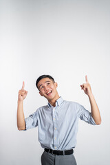 happy businessman asian looking up and pointing to blank space