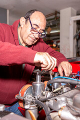 retiree enjoying his hobby of restoring a vehicle in his spare time