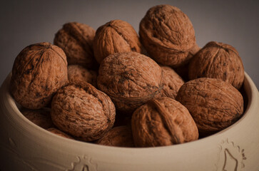 walnuts with a clear texture close-up in a clay bowl on a gray background