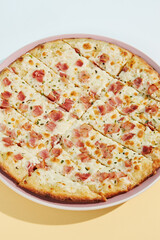 Italian pizza with bacon and cheese on coloured background. Cheese focaccia with bacon in minimal style on blue colour. American pizza delivery concept with color backdrop