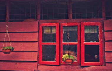 Fototapeta na wymiar North Bengal, India, 2022, A vintage house decorated with planted trees on pots and a window behind the balcony.