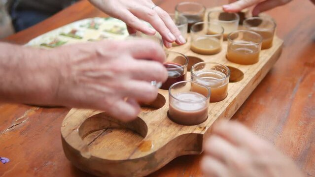 BALI, INDONESIA - JANUARY 22, 2018: Close-up view of tourists hands and tray with various coffee and tea drinks at kopi luwak farm during the degustation, Bali. 4K, Handheld