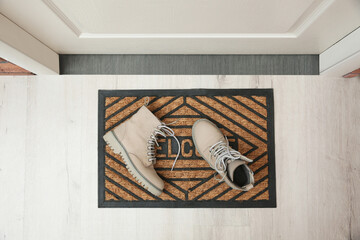 Stylish shoes on door mat in hall, top view