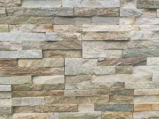 Wall. Photograph of an exterior brick wall in various shades of brown. Wall texture. Horizontal photography.	