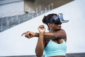 Fit african woman wearing virtual reality headset during workout routine - Metaverse concept -...