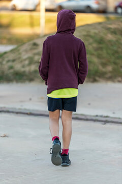 Rear view of a young hooded boy walking away