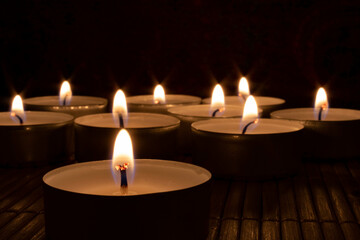 Close-up of lit candles In darkroom. Romance, hope, peace concept