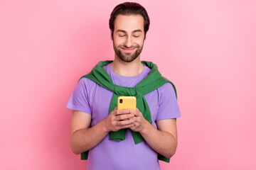 Photo of handsome good mood male chatting with girlfriend in social network isolated on pink color background