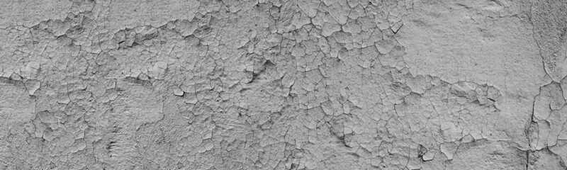 Old cracked grey exterior wall wide panoramic texture. Shabby rough damaged surface. Abstract large long grunge background