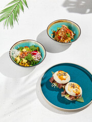 Set of asian dishes: bao buns with beef, poke bowl and fried udon with chicken and bacon. Pan asian...