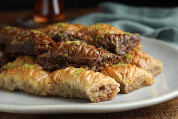 Delicious baklava with pistachios on wooden table, closeup