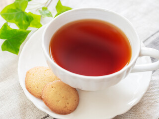 カップに入った紅茶とソーサの上のラングドシャ・クッキー