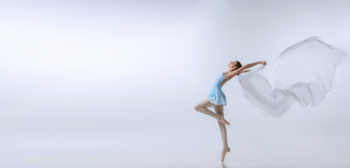 Flyer with young girl, aspiring ballerina in blue dress and pointes dancing with cloth isolated on gray background. Art, grace, beauty, ballet school concept