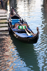 Obraz premium A gondola moored in a canal at sunset. Venezia, Italy