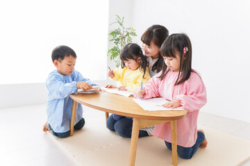 お絵かきをする子どもたちと保育士